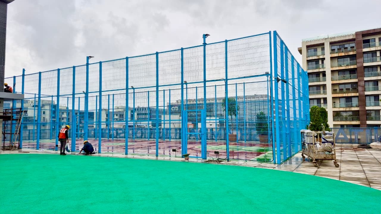 Full-height court enclosure fencing integrated seamlessly next to adjacent towers